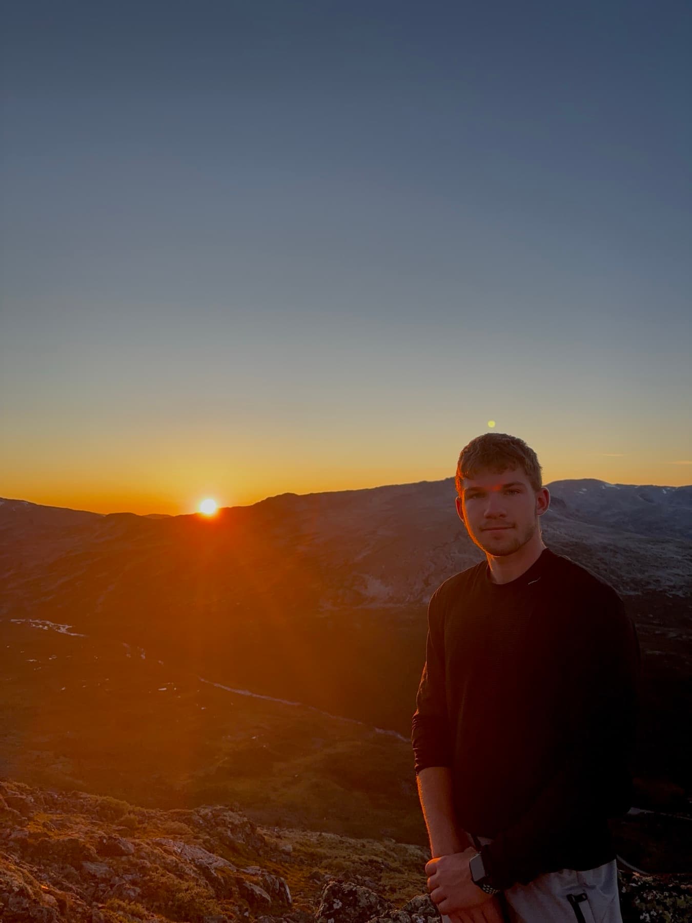 Adam Krenc na horském hřebeni při západu slunce